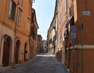 A cobbled lane runs between warm-toned buildings with shuttered windows; the Vignatagliata street sign is visible at the corner.