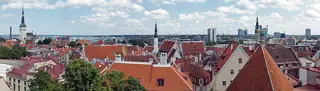 A long panorama of red rooftops, church towers and smaller modern buildings on the distant skyline.