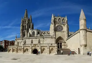Carved stone portals, a rose window and Gothic towers rise above a broad paved square.
