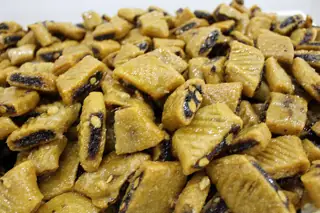 Regional illustration, exact location unstated: a heap of cut makroudh pastries with dark filling.