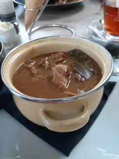 Regional food illustration of Flemish beef stew in a plain pot; capture location is unspecified.