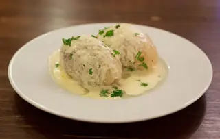 Two cepelinai on a plain white plate, photographed at a Vilnius restaurant in 2014.